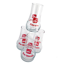 Load image into Gallery viewer, Vintage set of four, 7Up bilingual upside down drinking glasses with the 7Up logo in red along with their classic tagline, &quot;The Uncola&quot; in English and &quot;L&#39;encola&quot; in French. The glass come in the original cardboard tube with 7Up logo and red plastic end caps. Crafted by Libbey Glass, Canada, circa 1970s. A great addition to promotional advertising and glassware collections!  Glasses are in excellent condition, never used, no chips/wear. The tube has water damage, but still sturdy. Each glass is marked with t
