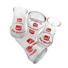 Load image into Gallery viewer, Vintage set of four, 7Up bilingual upside down drinking glasses with the 7Up logo in red along with their classic tagline, &quot;The Uncola&quot; in English and &quot;L&#39;encola&quot; in French. The glass come in the original cardboard tube with 7Up logo and red plastic end caps. Crafted by Libbey Glass, Canada, circa 1970s. A great addition to promotional advertising and glassware collections!  Glasses are in excellent condition, never used, no chips/wear. The tube has water damage, but still sturdy. Each glass is marked with t
