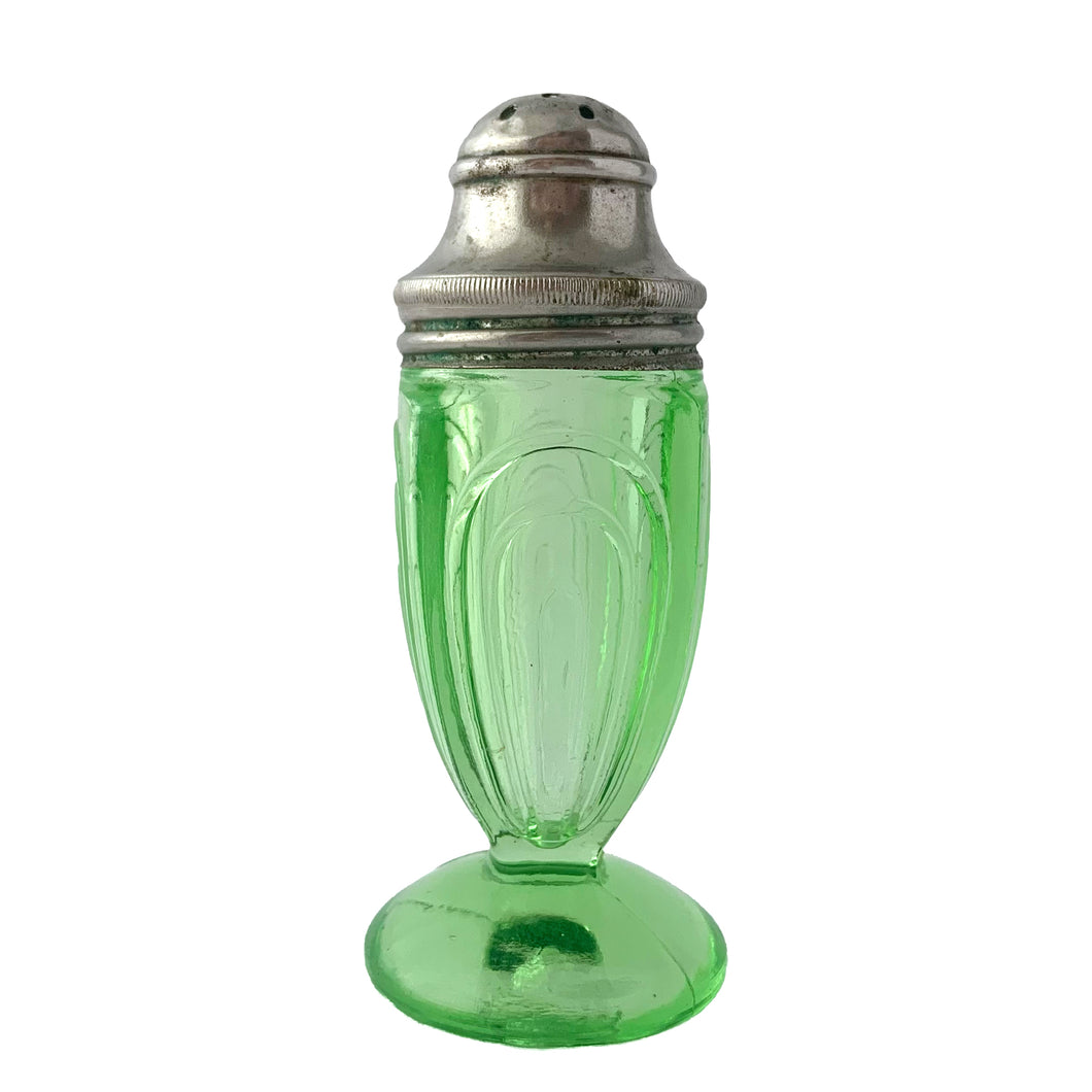 Antique vintage depression era art deco  Arches or 50R3506 footed salt or pepper uranium glass shaker with metal lid. Crafted by Hazel-Atlas Glass, USA, 1920s. This timeless kitchen accessory and its novel green uranium glass glows brilliantly under black light, adding a unique accent to your kitchen and table decor!  In excellent condition, no chips. Minor wear to the lid.  Measures 1 1/2 x 3 5/8 inches