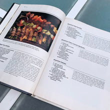 Load image into Gallery viewer, Better Homes and Gardens is known for its fabulous cookbooks. This hardcover cookbook focuses on their all time favourite barbecue inspired recipes. Its 96 pages are filled with amazing  recipes along with many colour photographs. Originally published by Meredith Corporation, USA, 1977. This is the fourth printing 1984.   In great vintage condition with normal age-related yellowing.
