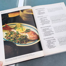 Load image into Gallery viewer, Better Homes and Gardens is known for its fabulous cookbooks. This hardcover cookbook focuses on their all-time favourite fish and seafood inspired recipes. Its 96 pages are filled with amazing recipes along with many colour photographs. Originally published by Meredith Corporation, USA, 1980. This is the large format edition, first printing 1983.   In great vintage condition with normal age-related yellowing.
