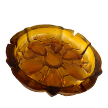 Load image into Gallery viewer, This vintage mid-century art glass amber ashtray features a textured outer surface and sunflower design. Circa 1960s. Possibly made using a sand cast mold process.  In excellent condition, free from chips.  Measures 7 1/2 x 2 3/4 inches
