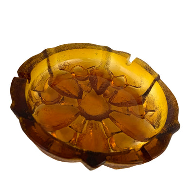 This vintage mid-century art glass amber ashtray features a textured outer surface and sunflower design. Circa 1960s. Possibly made using a sand cast mold process.  In excellent condition, free from chips.  Measures 7 1/2 x 2 3/4 inches