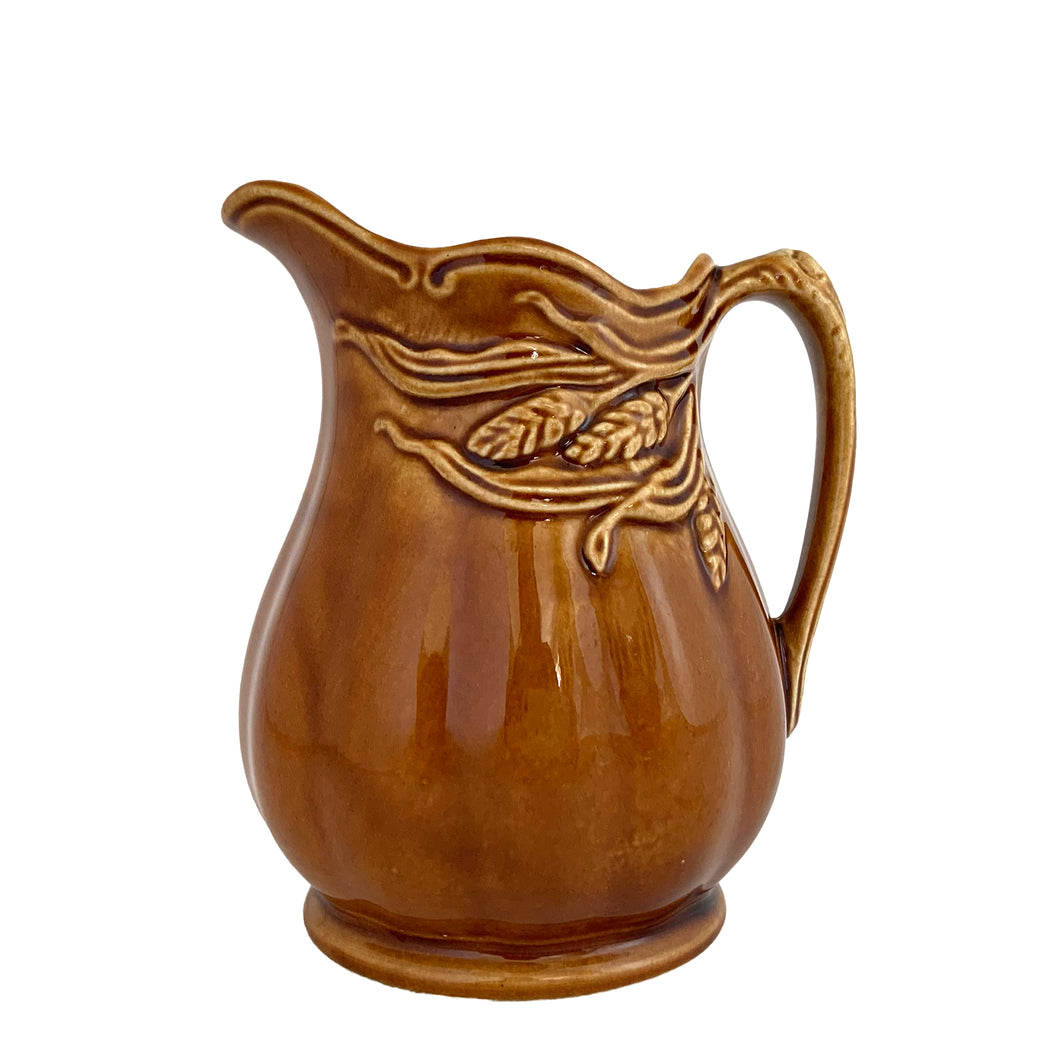 Vintage amber glazed ironstone creamer pitcher featuring a wheat motif. Crafted by Arthur Wood. England. 1950s. Perfect to use as intended or as part of your farmhouse, country and cottagecore decor.

Excellent condition, no chips/cracks/repairs. Crazing present. Marked on the bottom.

Measures 4 2 5/8 x 4 5/8 inches