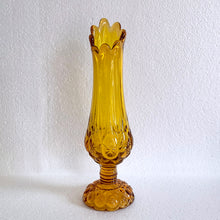 Load image into Gallery viewer, Glow in the dark elegance! Show off your daring style with this vintage mid-century &quot;Moon and Stars&quot; art glass swung vase that glows under black light. Crafted from amber glass with a striking moon and stars design, this American-made Kanawha Glass vase would be an unforgettable addition to any decor!  In excellent condition, free from chips/cracks.  Measures 3 1/2 x 12 1/8 inches
