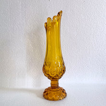 Load image into Gallery viewer, Glow in the dark elegance! Show off your daring style with this vintage mid-century &quot;Moon and Stars&quot; art glass swung vase that glows under black light. Crafted from amber glass with a striking moon and stars design, this American-made Kanawha Glass vase would be an unforgettable addition to any decor!  In excellent condition, free from chips/cracks.  Measures 3 1/2 x 12 1/8 inches
