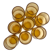 Load image into Gallery viewer, Overhead view of 8 vintage amber Libbey Tempo juice glasses showing open rims and amber glass interiors
