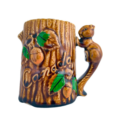 Vintage souvenir of Canada figural woodland mug featuring a tree trunk design with embossed acorns, the word 