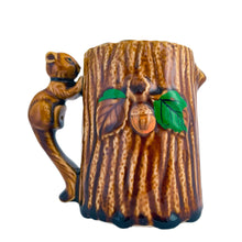 Load image into Gallery viewer, Vintage souvenir of Canada figural woodland mug featuring a tree trunk design with embossed acorns, the word &quot;Canada&quot; and an adorable figural squirrel handle. Crafted in Japan, circa 1950/60s. A sweet piece of Canadiana!  In excellent condition, free from chips/cracks/repairs.  Measures 3 1/2 x 4 1/2 inches
