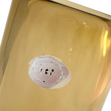 Load image into Gallery viewer, Vintage modernist amber glass vase featuring a clear base with bubble. Crafted by Magnor Glassverk, Norway, 1960s. A stunning piece of art glass to elevate your home's decor.

In excellent condition, no chips. Original tag.

Measures 2 3/4 x 7 1/8 inches
