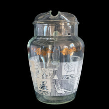 Load image into Gallery viewer, Vintage 64 oz clear glass ice lip pitcher with ribbed handle features a block printed design early American heritage scenes in white with a band of gold eagles and stars. Crafted by Anchor Hocking, USA, 1950s. A great way to show off your patriotic style!

In excellent condition, no chips, minor wear to the gold.

Measures 6 1/2 x 5 1/2 x 9 inches

Capacity 64 ounces
