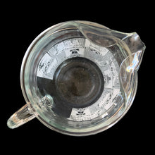 Load image into Gallery viewer, Vintage 64 oz clear glass ice lip pitcher with ribbed handle features a block printed design early American heritage scenes in white with a band of gold eagles and stars. Crafted by Anchor Hocking, USA, 1950s. A great way to show off your patriotic style!

In excellent condition, no chips, minor wear to the gold.

Measures 6 1/2 x 5 1/2 x 9 inches

Capacity 64 ounces
