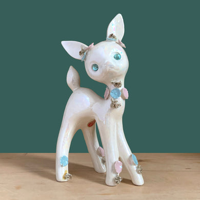 Adorable vintage mid-century era anthropomorphic deer ceramic figurine, glazed in iridescent white with blue rhinestone eyes, pink and blue flowers and gold gilt spaghetti details. Crafted by Lefton, Japan, circa 1950s. This sweet-faced deer is sure to delight everyone and it will make a wonderful addition to your Christmas holiday decor!

In good vintage condition. There is a chip to one blue flower, but otherwise excellent. Marked Japan and number 5845.

Measures 3 1/2 x 2 1/2 x 7 inches