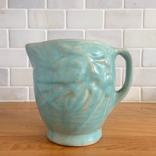 Load image into Gallery viewer, Vintage matte aqua glazed Bird in Berries pitcher. Crafted by McCoy Pottery, USA, 1935. This rare and highly collectible pitcher is the perfect for flowers or decorative display and makes a lovely gift for an art pottery collector.

In excellent vintage condition, no chips,cracks or repairs, manufacturer&#39;s glaze pops. Unmarked.

Measures 4 x 5 3/4 x 4 7/8 inches (incl. handle/spout)
