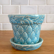 Load image into Gallery viewer, Vintage Art Deco aqua blue Tierra Cushion planter with attached underplate. Crafted by McCoy Pottery, 1950. This rare piece is must for any art pottery collector! A lovely way to enhance your home's decor or give as a gift!

In excellent vintage condition, no chips/cracks/repairs. Typical age-related crazing, manufacturer's glaze pops. Maker's marks.

Measures 4 x 3 3/8 inches
