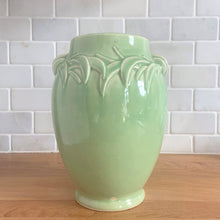 Load image into Gallery viewer, Vintage mid-century gloss aqua handled vase with embossed leaves. Crafted by McCoy Pottery, 1948. This lovely vase is must for any art pottery collector!

In excellent condition, no chips/cracks/repairs, crazing commensurate with age and manufacturing glaze pops. Maker&#39;s mark on the bottom.

Measures 5 1/2 x 8 inches
