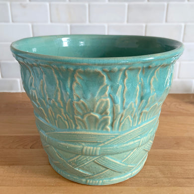Vintage art deco gloss aqua ceramic jardiniere planter no. 112, featuring repeating columns of stacked palm leaves atop a basket weave pattern. Crafted by Robinson Ransbottom Pottery Co., USA, 1930s. A beautiful piece to add to your art pottery collection!

In as found vintage condition, no chips/repairs, tight hairline crack, age-related crazing, typical manufacturing glaze pops. Unmarked.

Measures 9 1/4 x 7 1/4 inches