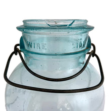 Load image into Gallery viewer, Vintage Perfect Seal aqua glass mason jar,featuring glass lid and wire bail closure. Produced by the Hamilton Glass Works in the early 20th century. These jars are fabulous for storing dry goods or may be repurposed as a vase. Perfect for farmhouse and cottage core decor.  In as found condition.  Measures 4 1/2 x 9 1/2 inches  Capacity 2 quarts (1/2 gallon)
