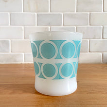 Load image into Gallery viewer, Highly collectible vintage Fire-King Ware milk glass mug with two rows of turquoise rings, D-handle. Crafted by Anchor Hocking, USA, 1960s. A must-have for any Fire-King collector!

In excellent condition, no chips, cracks or repairs. Paint is vibrant and shiny.

Measures 3 1/4 x 3 3/8 inches
