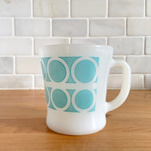 Load image into Gallery viewer, Highly collectible vintage Fire-King Ware milk glass mug with two rows of turquoise rings, D-handle. Crafted by Anchor Hocking, USA, 1960s. A must-have for any Fire-King collector!

In excellent condition, no chips, cracks or repairs. Paint is vibrant and shiny.

Measures 3 1/4 x 3 3/8 inches
