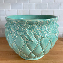 Load image into Gallery viewer, Large vintage aqua gloss glazed Tierra Cushion jardiniere planter pot, features an overlapping floral leaf rim and diamond quilted body with ribbon handles. Crafted by McCoy Pottery, USA, 1950s. A must-have for any McCoy collector or container gardener!

In excellent condition, no chips/cracks/repairs, manufacturer&#39;s glaze pops. Maker&#39;s mark.

Measures 10 3/8 x 8 1/2 inches

