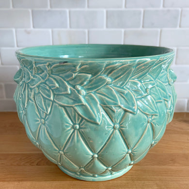Large vintage aqua gloss glazed Tierra Cushion jardiniere planter pot, features an overlapping floral leaf rim and diamond quilted body with ribbon handles. Crafted by McCoy Pottery, USA, 1950s. A must-have for any McCoy collector or container gardener!

In excellent condition, no chips/cracks/repairs, manufacturer's glaze pops. Maker's mark.

Measures 10 3/8 x 8 1/2 inches