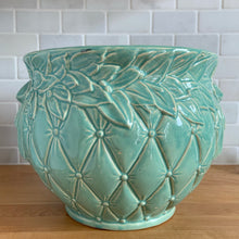 Load image into Gallery viewer, Large vintage aqua gloss glazed Tierra Cushion jardiniere planter pot, features an overlapping floral leaf rim and diamond quilted body with ribbon handles. Crafted by McCoy Pottery, USA, 1950s. A must-have for any McCoy collector or container gardener!

In excellent condition, no chips/cracks/repairs, manufacturer&#39;s glaze pops. Maker&#39;s mark.

Measures 10 3/8 x 8 1/2 inches
