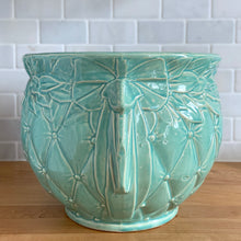 Load image into Gallery viewer, Large vintage aqua gloss glazed Tierra Cushion jardiniere planter pot, features an overlapping floral leaf rim and diamond quilted body with ribbon handles. Crafted by McCoy Pottery, USA, 1950s. A must-have for any McCoy collector or container gardener!

In excellent condition, no chips/cracks/repairs, manufacturer&#39;s glaze pops. Maker&#39;s mark.

Measures 10 3/8 x 8 1/2 inches

