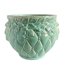 Load image into Gallery viewer, Large vintage TIerra Cushion jardiniere planter pot, aqua gloss glaze, features an overlapping floral leaf pattern around the top rim, a diamond quilted body and ribbon handles. Crafted by McCoy Pottery, USA, 1950s. A must-have for any McCoy collector or gardener!

In excellent condition, free from chips, cracks or repairs, with a manufacturer's defect at the rim, see photo. Maker's mark is on the bottom.

Measures 8 3/4 x 7 1/2 inches
