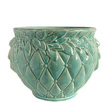 Load image into Gallery viewer, Large vintage TIerra Cushion jardiniere planter pot, aqua gloss glaze, features an overlapping floral leaf pattern around the top rim, a diamond quilted body and ribbon handles. Crafted by McCoy Pottery, USA, 1950s. A must-have for any McCoy collector or gardener!

In excellent condition, free from chips, cracks or repairs, with a manufacturer's defect at the rim, see photo. Maker's mark is on the bottom.

Measures 8 3/4 x 7 1/2 inches
