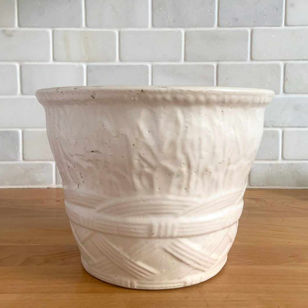 Vintage art deco matte white ceramic jardiniere planter featuring repeating columns of stacked palm leaves atop a basket weave pattern. Crafted by Robinson Ransbottom Pottery Co., USA, 1930s. A beautiful piece to add to your art pottery collection!

In excellent condition, no chips/cracks/repairs. Typical manufacturing glaze pops. Unmarked.

Measures 7 3/8 x 5 1/2 inches