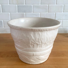 Load image into Gallery viewer, Vintage art deco matte white ceramic jardiniere planter featuring repeating columns of stacked palm leaves atop a basket weave pattern. Crafted by Robinson Ransbottom Pottery Co., USA, 1930s. A beautiful piece to add to your art pottery collection!

In excellent condition, no chips/cracks/repairs. Typical manufacturing glaze pops. Unmarked.

Measures 7 3/8 x 5 1/2 inches
