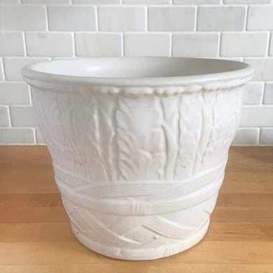 Vintage art deco matte white ceramic jardiniere planter featuring repeating columns of stacked palm leaves atop a basket weave pattern. Crafted by Robinson Ransbottom Pottery Co., USA, 1930s. A beautiful piece to add to your art pottery collection!

In excellent condition, no chips/cracks/repairs. Typical manufacturing glaze pops. Unmarked.

Measures 10 1/2 x 8 1/2 inches