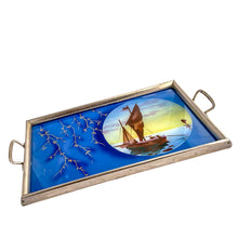 Load image into Gallery viewer, Stunning art deco reverse painted tray with metal frame and handles. Depicts sailboats on the water within a circle on a royal blue background with gold trailing leaves lending itself nicely to a Hollywood Regency or Chinoiserie decor. Germany, 1920s. Perfect as a vanity tray, service barware or even wall art.

The painting is in excellent condition with age-related wear to the frame.

Measures 14 1/8 x 8 3/4 (not incl. handles)
