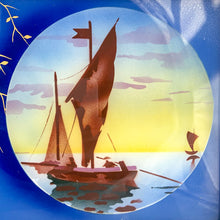 Load image into Gallery viewer, Stunning art deco reverse painted tray with metal frame and handles. Depicts sailboats on the water within a circle on a royal blue background with gold trailing leaves lending itself nicely to a Hollywood Regency or Chinoiserie decor. Germany, 1920s. Perfect as a vanity tray, service barware or even wall art.

The painting is in excellent condition with age-related wear to the frame.

Measures 14 1/8 x 8 3/4 (not incl. handles)
