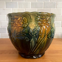 Load image into Gallery viewer, Vintage Art Nouveau drip glazed majolica footed ceramic jardiniere planter features a floral pattern in green, ochre and navy, with scalloped rim. Attributed to WF Needham, England, early 1900s. Fill this beauty with your favourite plants or use as decor!

In excellent condition, no chips/cracks/repairs, normal age-related crazing. Unmarked.

Measures 8 x 6 1/4 inches
