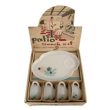Load image into Gallery viewer, This delightful vintage mid-century era Atomic Flower eight piece milk glass snack plate and cup set captures the perfect balance between classic style and sophistication. The plates are offset oval shaped and both plate and cup feature a sweet pattern of florals in shades of turquoise, pink, yellow and black. Crafted by Federal Glass, USA, circa 1950s. New old stock in original box. In like-new vintage condition, no chips, cracks or wear.

Snack plates measure 7x10 inches Cups measure 3 1/4x2 1/2 inches
