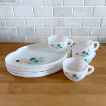 Load image into Gallery viewer, This delightful vintage mid-century era Atomic Flower eight piece milk glass snack plate and cup set captures the perfect balance between classic style and sophistication. The plates are offset oval shaped and both plate and cup feature a sweet pattern of florals in shades of turquoise, pink, yellow and black. Crafted by Federal Glass, USA, circa 1950s. New old stock in original box. In like-new vintage condition, no chips, cracks or wear.

Snack plates measure 7x10 inches Cups measure 3 1/4x2 1/2 inches

