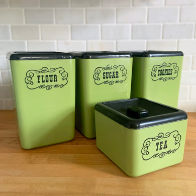 Vintage set of four retro avocado green plastic kitchen canisters topped with brown lids. Each has funky retro deboosed typography in brown. Includes flour, sugar, cookies and tea. Crafted by Beacon Plastics, Canada, 1970s. Add these beauties to retro-fy your kitchen countertop!

In great vintage condition. These canisters appear to be well cared for, with age appropriate wear to the plastic. Maker's mark on the bottom.