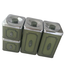 Load image into Gallery viewer, Vintage set of four avocado green retro kitchen canisters topped with chrome lids and green knobs. Each has period style typography in green plastic medallion with a silver letter to represent flour, sugar, coffee and tea. EKCO, Canada, 1970s. Add these beauties to retrofy your countertop! Great vintage condition. Canisters appear to be well cared for, with age appropriate wear to the paint mainly on the Sugar and Flour canisters. Stamped on the bottom with Made in Canada.
