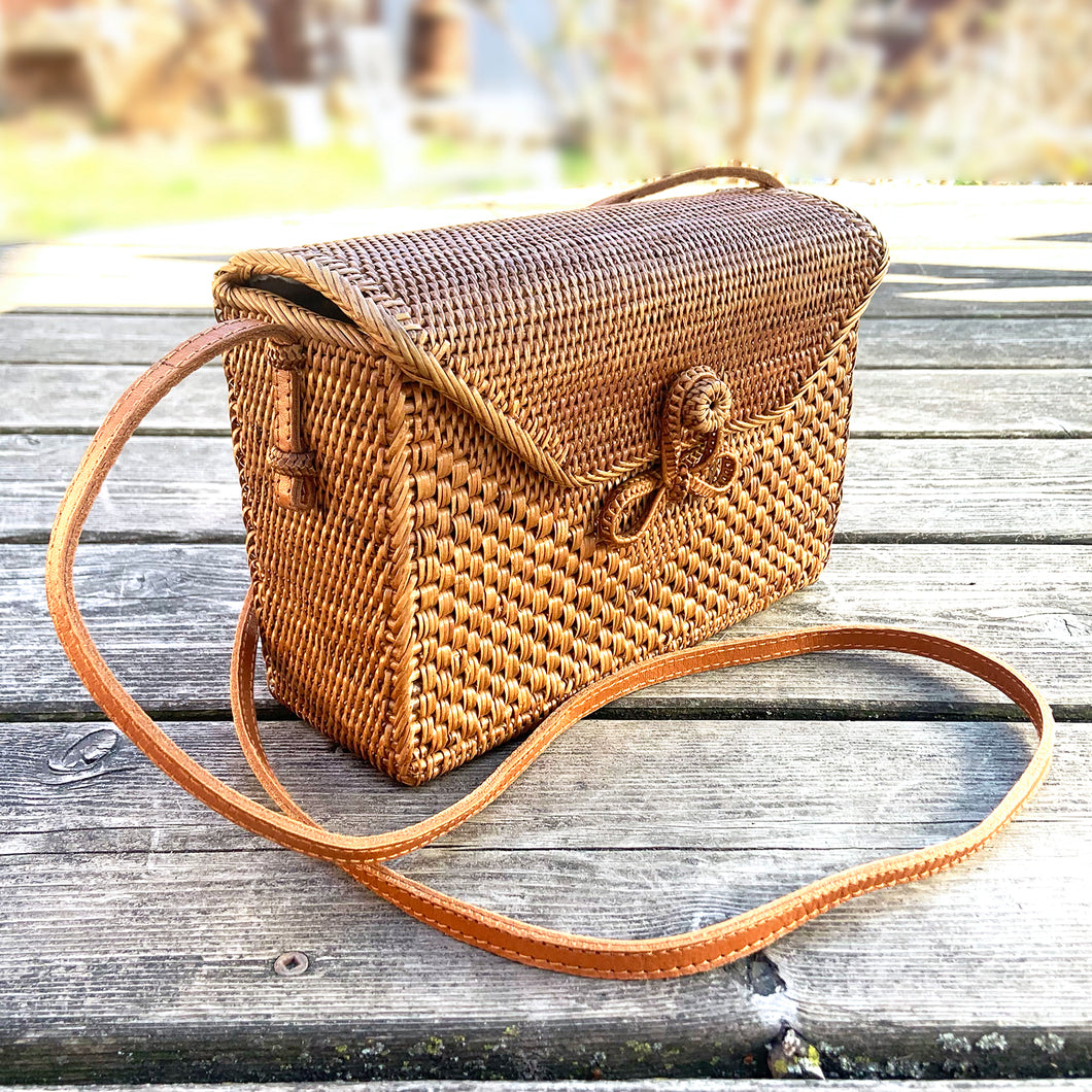 Lovely lightweight natural eastern Bali Ata Grass cross-body purse with loop closure, leather strap and cotton lining. Handcrafted by artisans using time-honoured techniques for Maker's Supply in Indonesia. Perfect for spring and summer, it adds a touch of casual sophistication to any feminine wardrobe.

The lining may have a water stain, but otherwise the purse is like-new and includes the original tags.

Measures 8 3/4 x 3 1/4 x 6 inches (28 inches with strap)