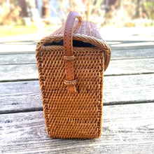 Load image into Gallery viewer, Lovely lightweight natural eastern Bali Ata Grass cross-body purse with loop closure, leather strap and cotton lining. Handcrafted by artisans using time-honoured techniques for Maker&#39;s Supply in Indonesia. Perfect for spring and summer, it adds a touch of casual sophistication to any feminine wardrobe.

The lining may have a water stain, but otherwise the purse is like-new and includes the original tags.

Measures 8 3/4 x 3 1/4 x 6 inches (28 inches with strap)
