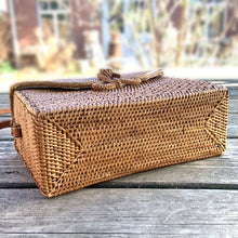 Load image into Gallery viewer, Lovely lightweight natural eastern Bali Ata Grass cross-body purse with loop closure, leather strap and cotton lining. Handcrafted by artisans using time-honoured techniques for Maker&#39;s Supply in Indonesia. Perfect for spring and summer, it adds a touch of casual sophistication to any feminine wardrobe.

The lining may have a water stain, but otherwise the purse is like-new and includes the original tags.

Measures 8 3/4 x 3 1/4 x 6 inches (28 inches with strap)
