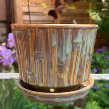 Load image into Gallery viewer, Vintage blended exotic brown glazed Bamboo ceramic planter with attached saucer from the Green Thumb Line. Crafted by McCoy Pottery, 1970s. A hard-to-find planter in a rare glaze. A must have for any art pottery collector. A sweet piece for your favourite houseplant or succulent.

In excellent vintage condition, no chips/cracks/repairs, typical age-related crazing and manufacturer's glaze pops. Maker's marks.

Measures 5 1/2 x 4 1/2 inches
