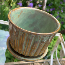 Load image into Gallery viewer, Vintage blended exotic brown glazed Bamboo ceramic planter with attached saucer from the Green Thumb Line. Crafted by McCoy Pottery, 1970s. A hard-to-find planter in a rare glaze. A must have for any art pottery collector. A sweet piece for your favourite houseplant or succulent.

In excellent vintage condition, no chips/cracks/repairs, typical age-related crazing and manufacturer's glaze pops. Maker's marks.

Measures 5 1/2 x 4 1/2 inches
