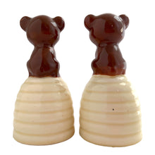 Load image into Gallery viewer, Vintage anthropomorphic bears on beehives ceramic salt and pepper shakers with plastic stoppers. Japan, 1970s. Add these adorable kitschy shakers to your collection!

In as found vintage condition, chip on bottom rim of one shaker, no cracks/repairs. Marked Japan.

Measures 2 1/4 x 2 1/4 x 4 1/2 inches
