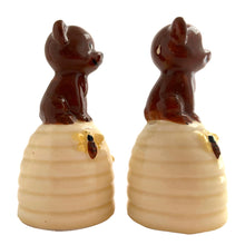 Load image into Gallery viewer, Vintage anthropomorphic bears on beehives ceramic salt and pepper shakers with plastic stoppers. Japan, 1970s. Add these adorable kitschy shakers to your collection!

In as found vintage condition, chip on bottom rim of one shaker, no cracks/repairs. Marked Japan.

Measures 2 1/4 x 2 1/4 x 4 1/2 inches
