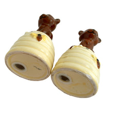 Load image into Gallery viewer, Vintage anthropomorphic bears on beehives ceramic salt and pepper shakers with plastic stoppers. Japan, 1970s. Add these adorable kitschy shakers to your collection!

In as found vintage condition, chip on bottom rim of one shaker, no cracks/repairs. Marked Japan.

Measures 2 1/4 x 2 1/4 x 4 1/2 inches
