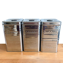 Load image into Gallery viewer, Front elevated view of Vintage Lincoln BeautyWare 4-piece chrome kitchen canister set, embossed Flour Sugar Coffee Tea lettering, ribbed steel, 1940s USA
