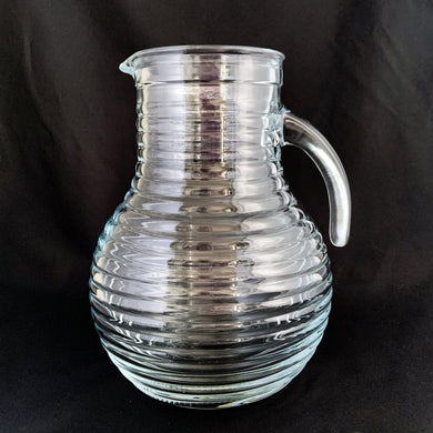 This vintage ribbed or beehive open handle pressed glass pitcher is perfect for water, lemonade, ice tea or the bevvy of your choosing. Made in Italy, circa 1960s.  In excellent condition, free from chips/cracks. Marked 